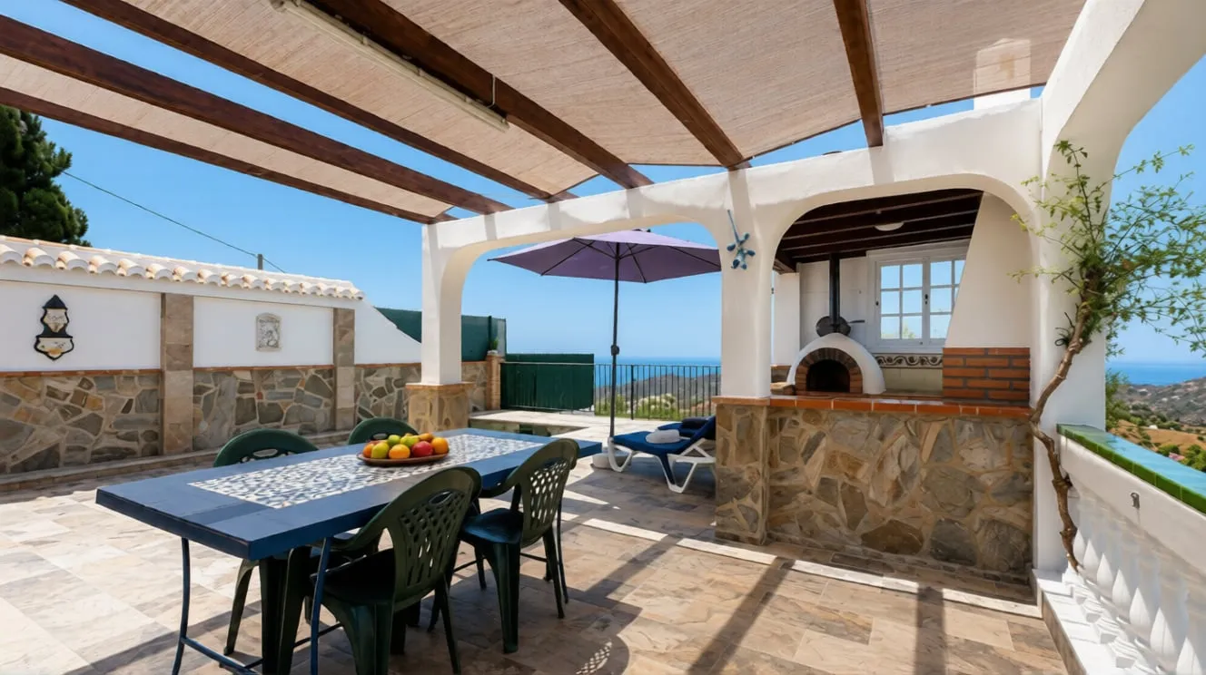 Terrace at El Olivo with pergola and wood-fired oven, the sea in the background