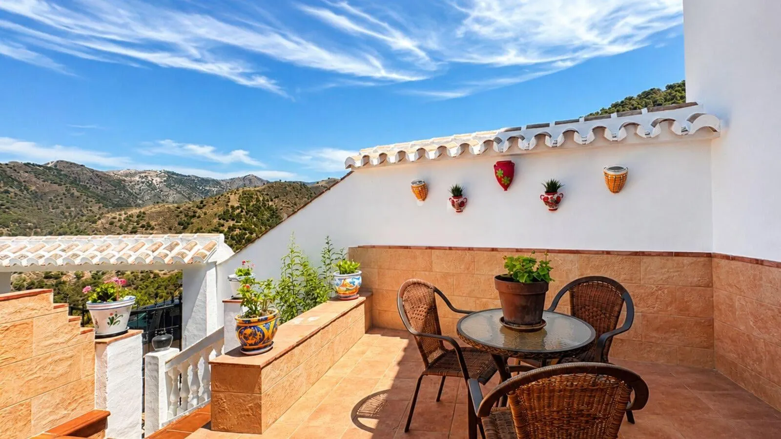Small upper terrace at El Olivo with painted pots and sea views