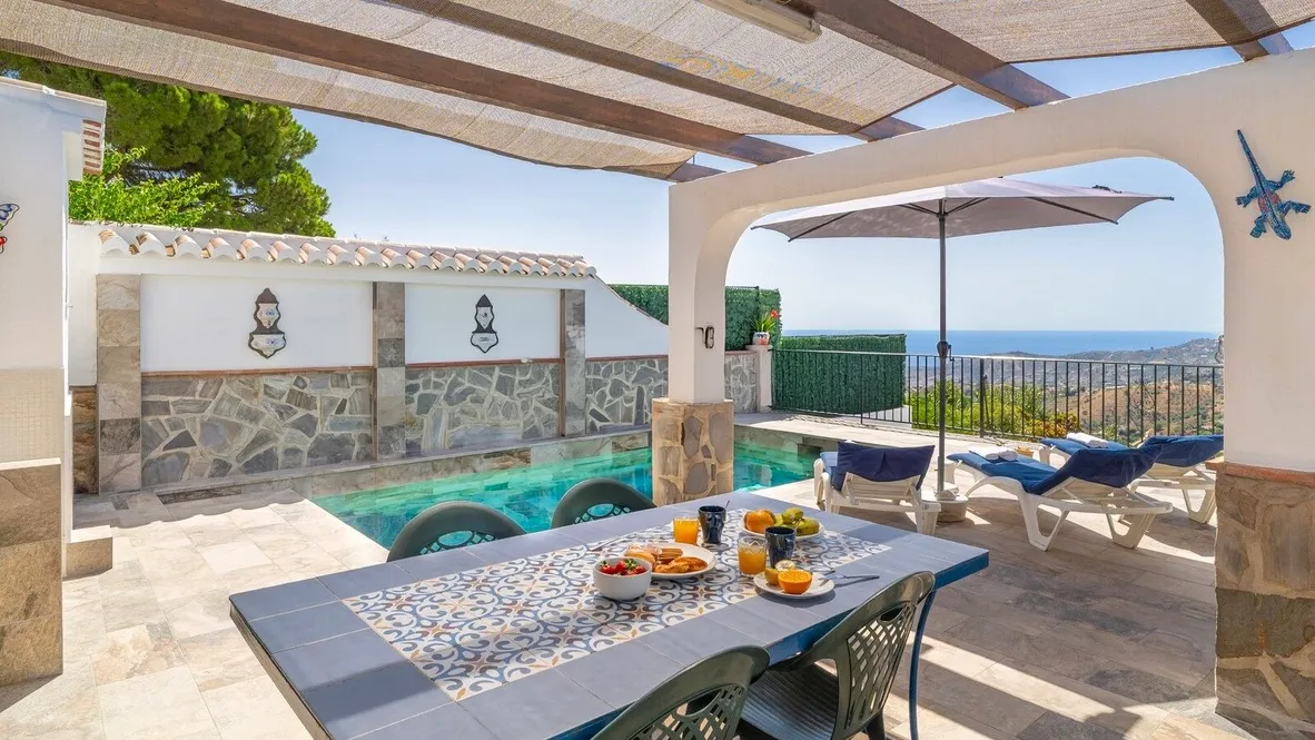 Covered dining terrace overlooking the pool and the sea