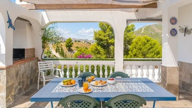Terrace table framed by arches and mountain views