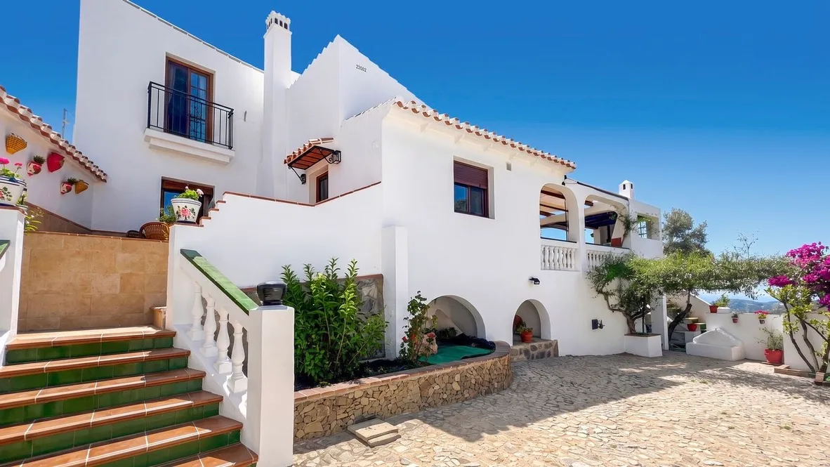 Whitewashed facade of El Olivo with tiled staircase and bougainvillea, Frigiliana