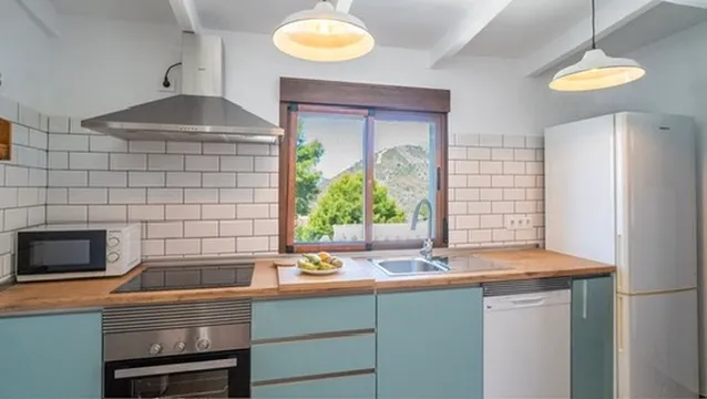 Fitted kitchen with a window onto the mountain